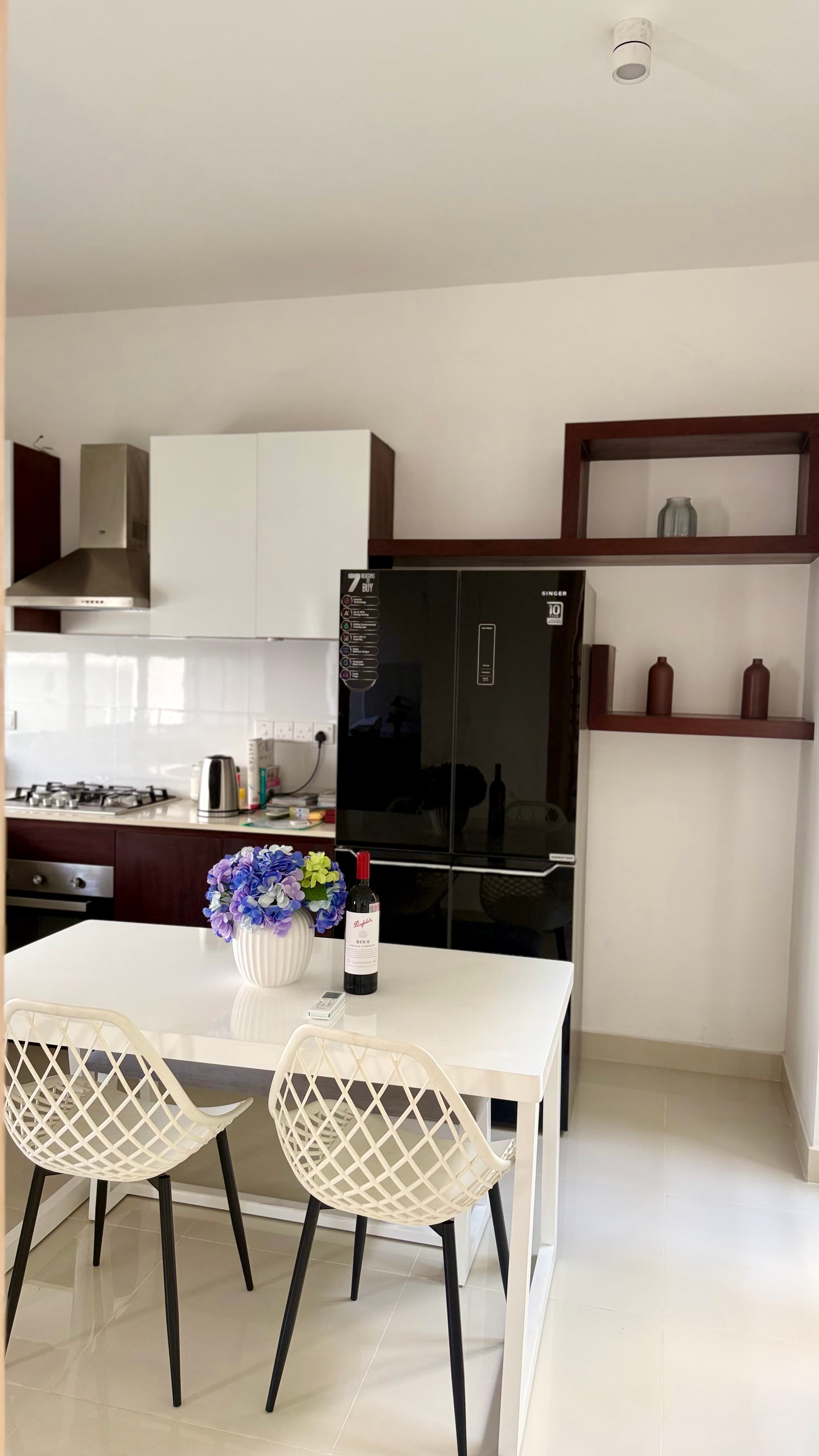 Villa 76 — fully equipped kitchen with walnut cabinetry, gas hob, built-in oven and large French-door refrigerator